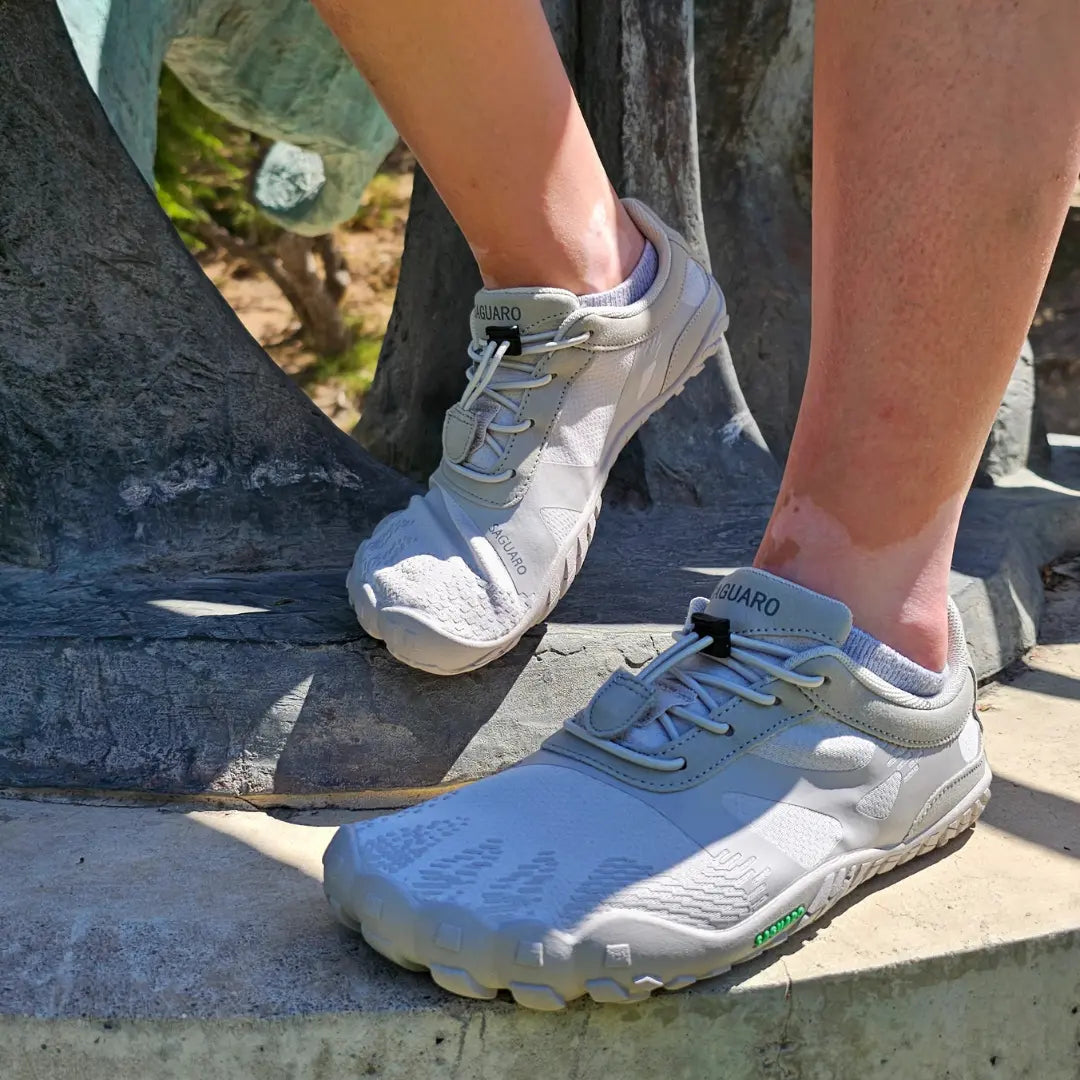 Persona usando zapatillas Saguaro Vitality III grises en exterior
