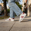 Persona usando zapatillas ZZfaber Niza I blanco con vinotinto en exterior.